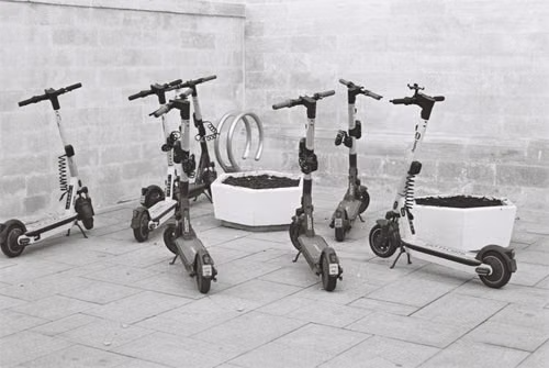 Patinete elétrico não liga: fileira de patinetes elétricos parados encostados na parede