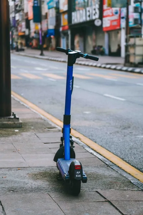 Patinete elétrico parado na calçada, ilustrando o custo de bateria de reposição