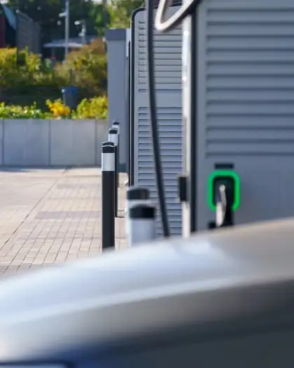 Estação de carregamento de veículo elétrico com conector e LED verde indicando carga